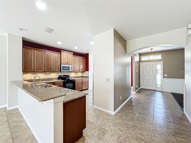 kitchen featuring sink, tasteful backsplash, black electric range oven, kitchen peninsula, and light tile patterned floors