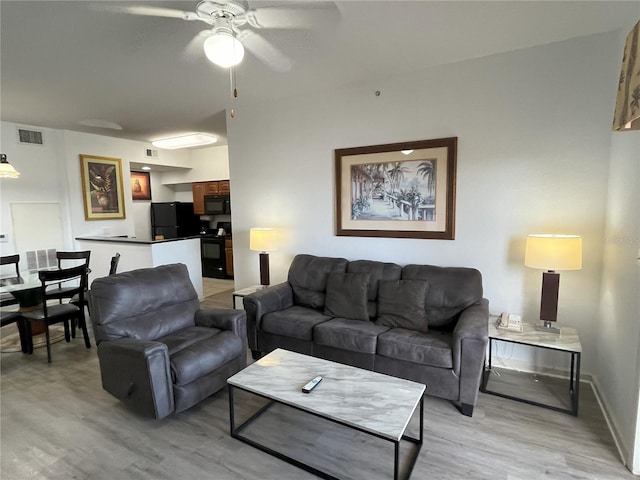 living area featuring a ceiling fan, visible vents, light wood-style flooring, and baseboards