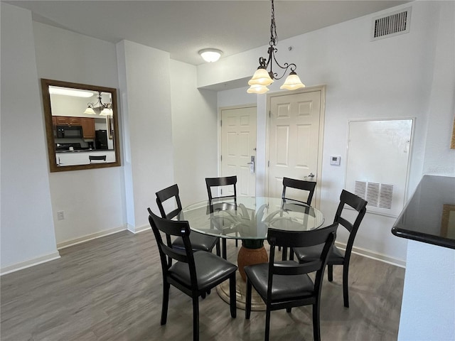 dining area with an inviting chandelier, baseboards, visible vents, and dark wood-type flooring