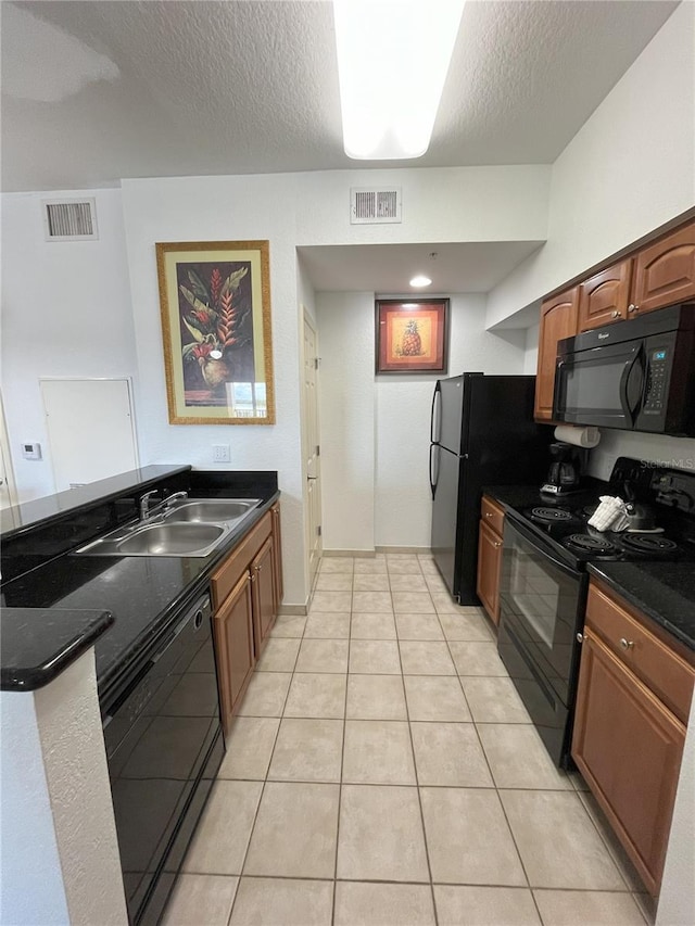 kitchen with brown cabinets, visible vents, a sink, a textured ceiling, and black appliances