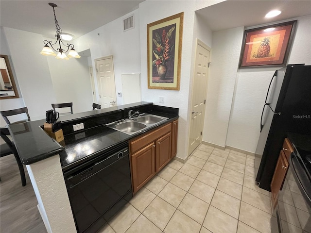 kitchen featuring visible vents, dark countertops, hanging light fixtures, black appliances, and a sink