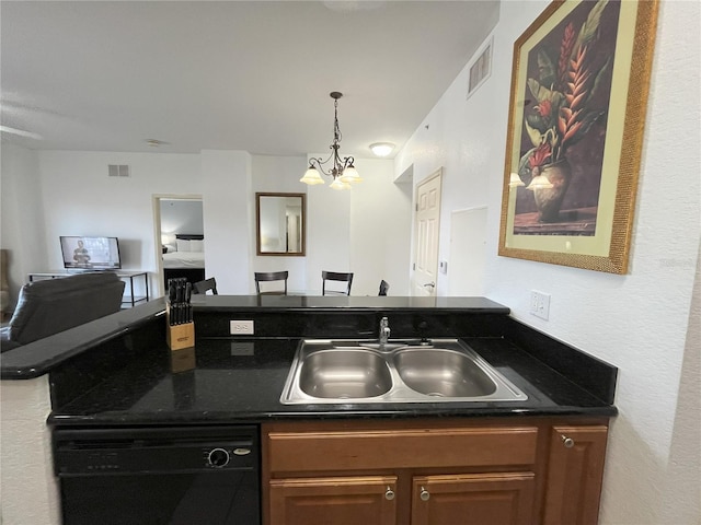 kitchen featuring black dishwasher, dark countertops, a sink, and brown cabinets