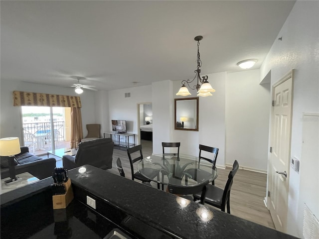 dining room with baseboards, visible vents, light wood-style flooring, and a ceiling fan