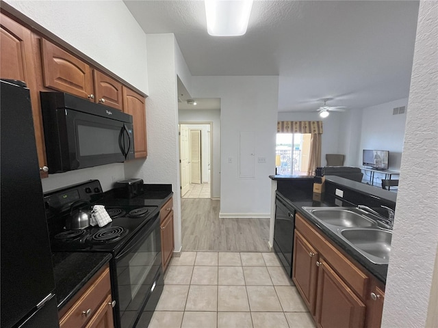 kitchen featuring dark countertops, visible vents, a sink, and black appliances