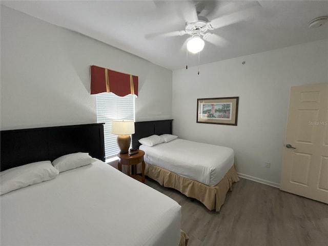 bedroom with baseboards, light wood-style flooring, and a ceiling fan