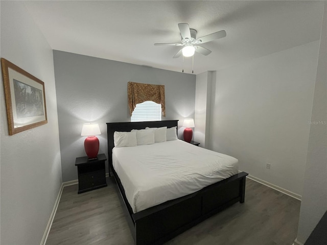 bedroom featuring dark wood finished floors, a ceiling fan, and baseboards