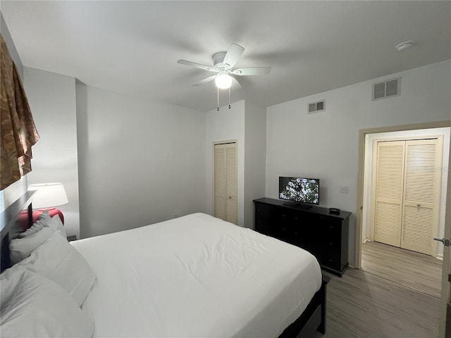 bedroom featuring ceiling fan, visible vents, and wood finished floors