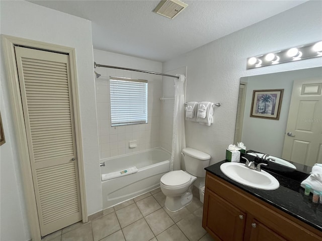 full bath featuring a closet, vanity, a textured ceiling, and tile patterned floors