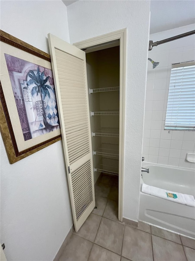 full bathroom featuring shower / bathtub combination, a closet, and tile patterned floors