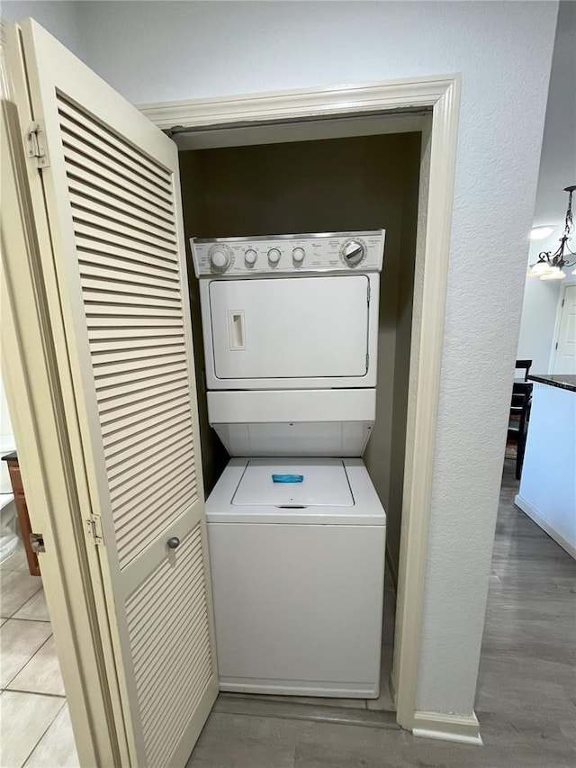 washroom with laundry area, light wood finished floors, and stacked washing maching and dryer