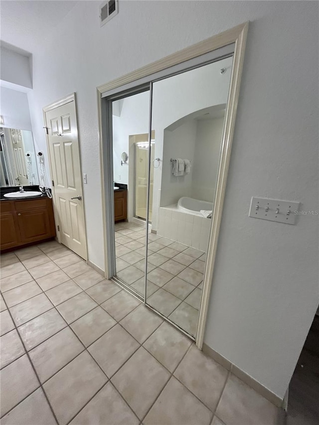 full bathroom with vanity, a garden tub, visible vents, and tile patterned floors