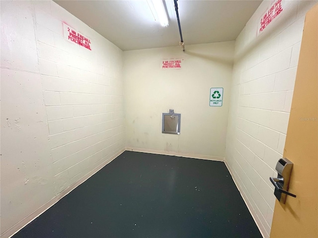 spare room with finished concrete flooring and concrete block wall