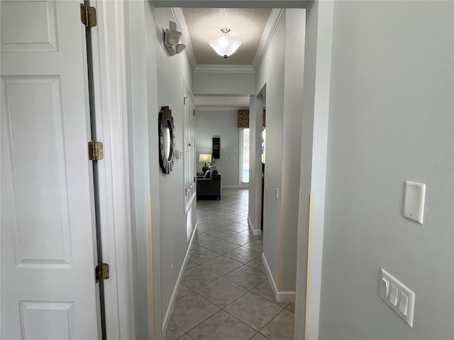 hall with light tile patterned flooring, crown molding, a textured ceiling, and baseboards