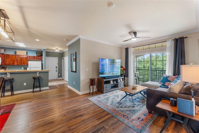 living room with light hardwood / wood-style floors, ornamental molding, and ceiling fan