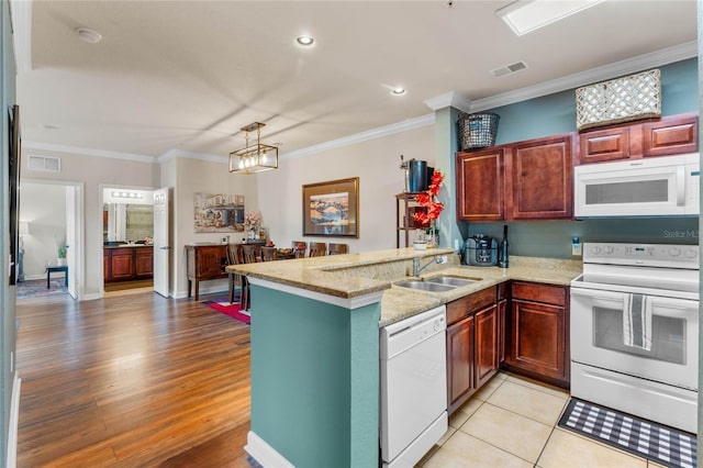 kitchen with crown molding, white appliances, light hardwood / wood-style flooring, and kitchen peninsula