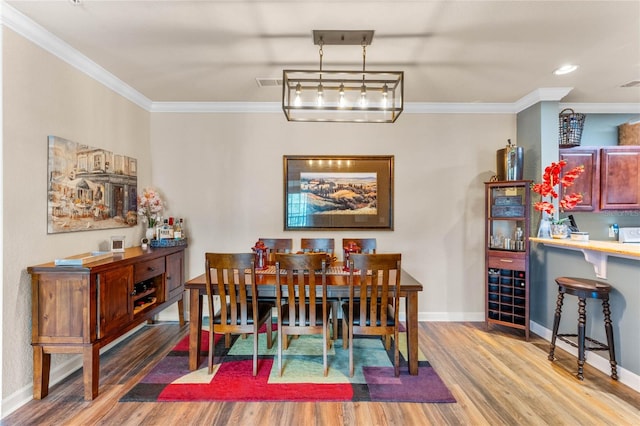 dining space featuring ornamental molding and hardwood / wood-style flooring