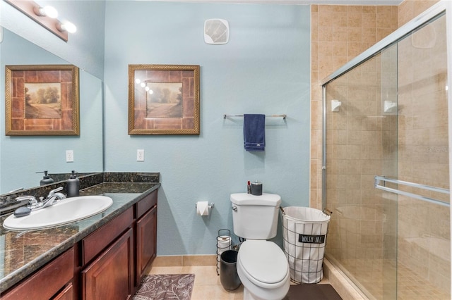 bathroom featuring a shower with shower door, vanity, tile patterned floors, and toilet