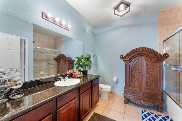 full bathroom with tile patterned flooring, a textured ceiling, toilet, vanity, and combined bath / shower with glass door