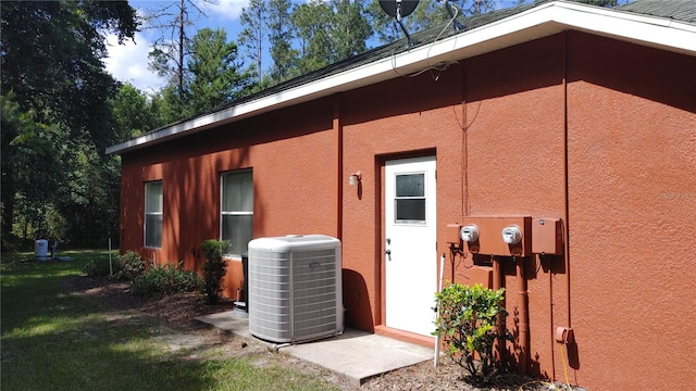 view of side of home with central AC