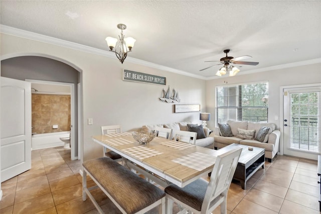 dining room with light tile patterned floors, ornamental molding, a textured ceiling, and arched walkways