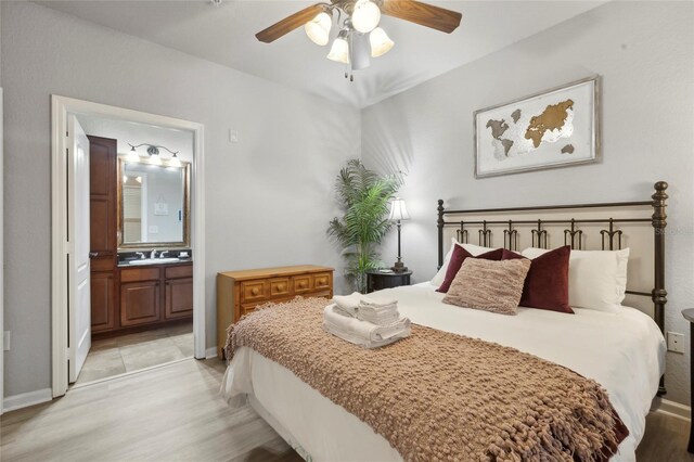 bedroom featuring sink, ceiling fan, connected bathroom, and light hardwood / wood-style floors