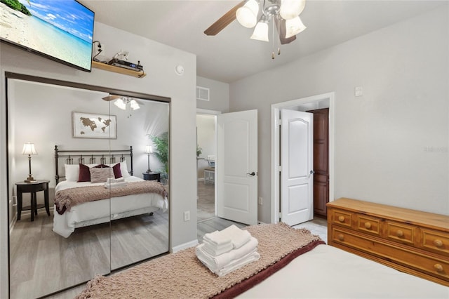 bedroom featuring light hardwood / wood-style flooring, ceiling fan, and a closet