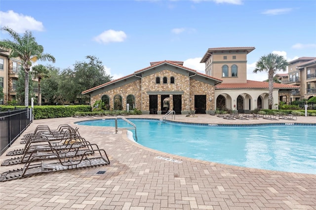 community pool featuring a patio and fence