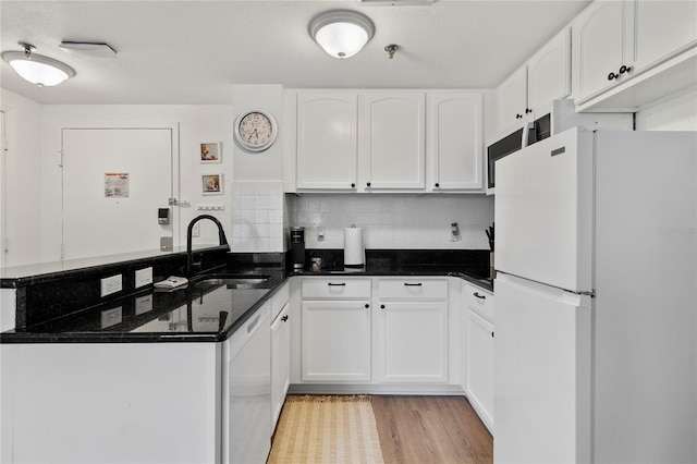 kitchen with white cabinets, light wood-type flooring, white appliances, sink, and kitchen peninsula