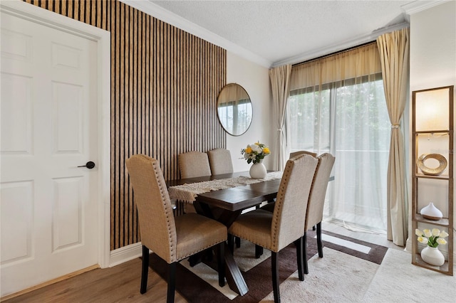 dining area featuring crown molding, a textured ceiling, and wood-type flooring