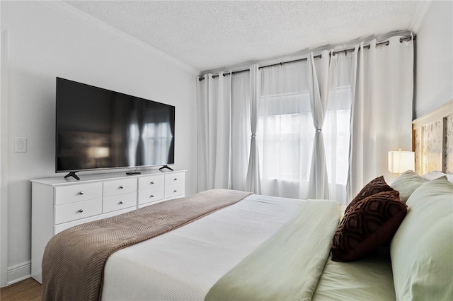 bedroom featuring crown molding, multiple windows, hardwood / wood-style floors, and a textured ceiling