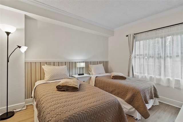 bedroom featuring crown molding, a textured ceiling, and light hardwood / wood-style floors