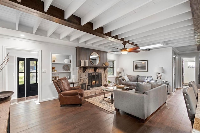 living room with beam ceiling, ceiling fan, a fireplace, and plenty of natural light