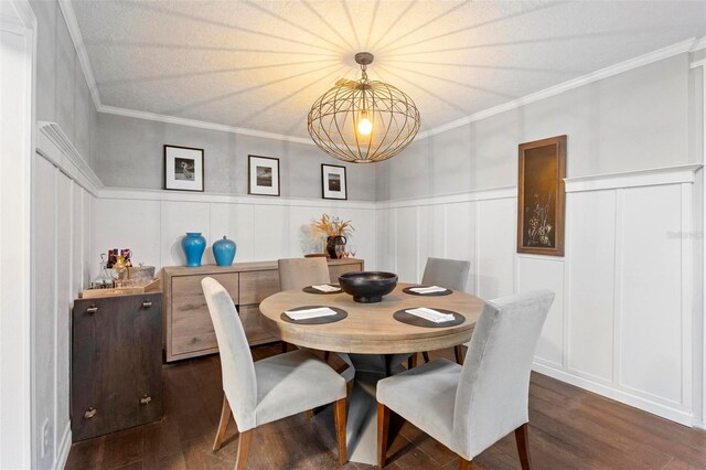 dining area with dark hardwood / wood-style flooring, ornamental molding, and a textured ceiling