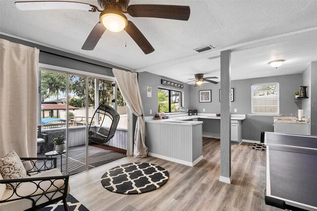 interior space with ceiling fan, a textured ceiling, and hardwood / wood-style flooring