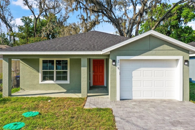 ranch-style home featuring a front lawn, covered porch, and a garage