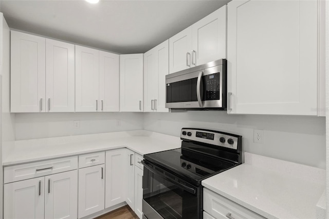 kitchen featuring white cabinets, stainless steel appliances, and light hardwood / wood-style floors