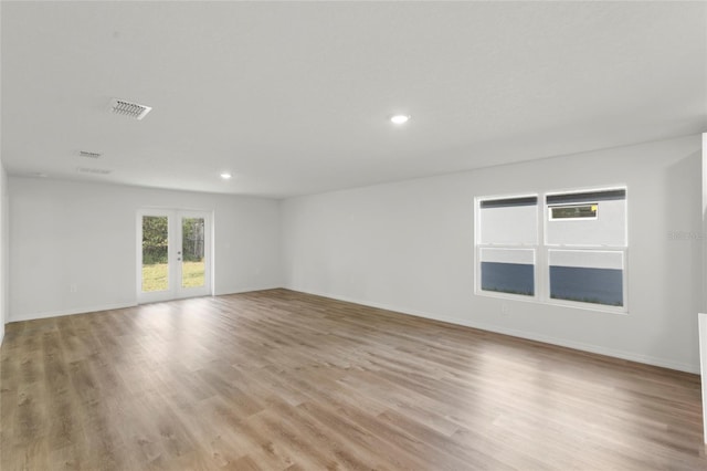 empty room with light hardwood / wood-style flooring and french doors