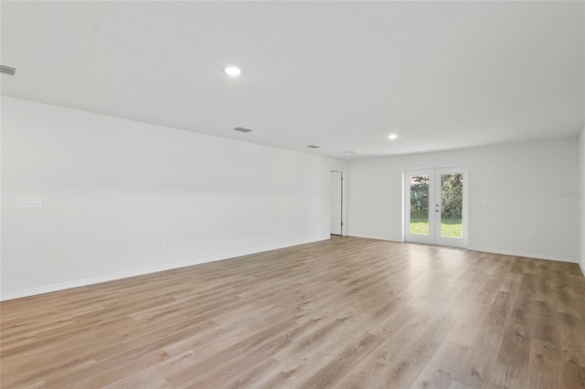 spare room with light hardwood / wood-style floors and french doors