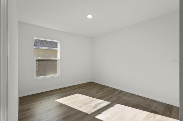 unfurnished room with dark wood-type flooring