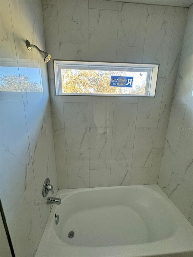 bathroom with tiled shower / bath and plenty of natural light