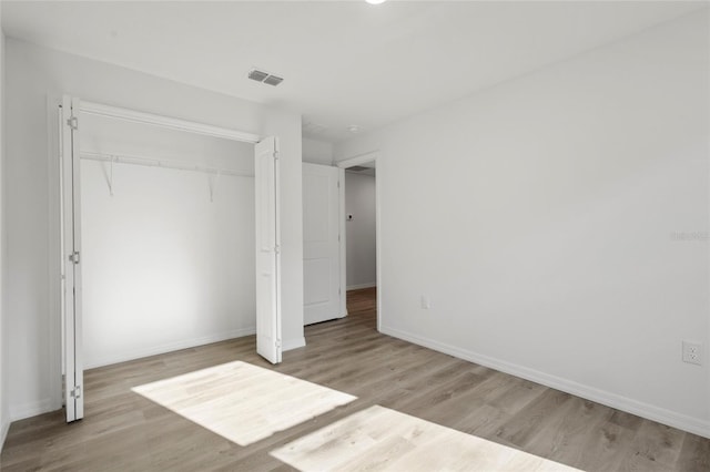 unfurnished bedroom featuring light hardwood / wood-style floors and a closet