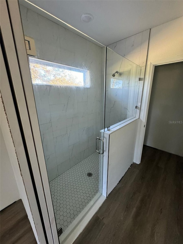 bathroom featuring hardwood / wood-style flooring and a shower with door