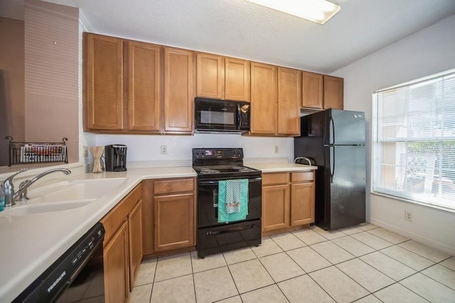 kitchen featuring light tile patterned flooring, black appliances, and sink