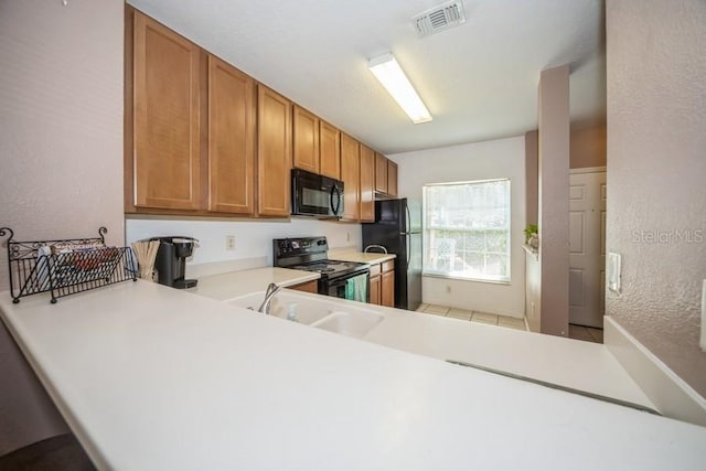 kitchen featuring sink, kitchen peninsula, and black appliances