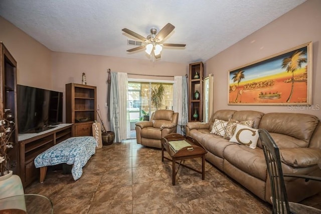 living room with a textured ceiling, tile patterned floors, and ceiling fan