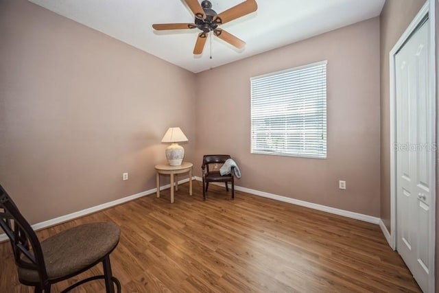 sitting room with ceiling fan and hardwood / wood-style floors