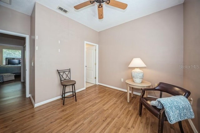 living area featuring ceiling fan and light hardwood / wood-style floors