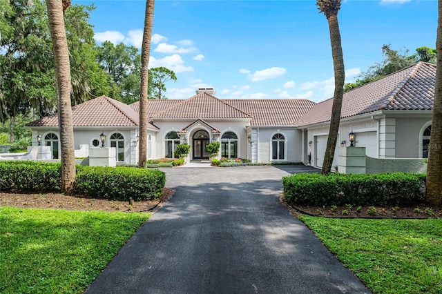 mediterranean / spanish house featuring a front lawn and a garage