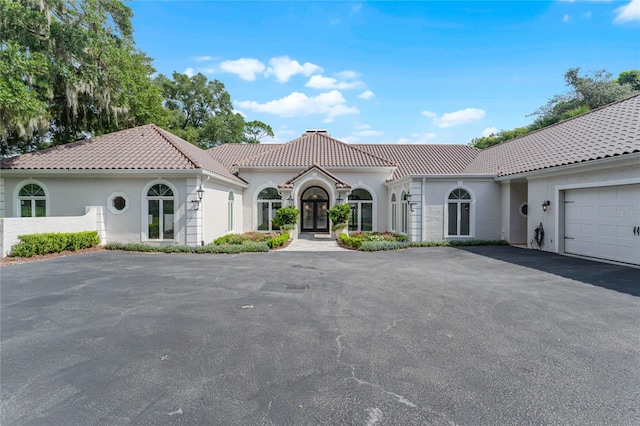 mediterranean / spanish-style house with a garage