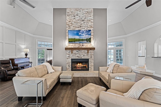 living room featuring ceiling fan, dark hardwood / wood-style flooring, a fireplace, and high vaulted ceiling